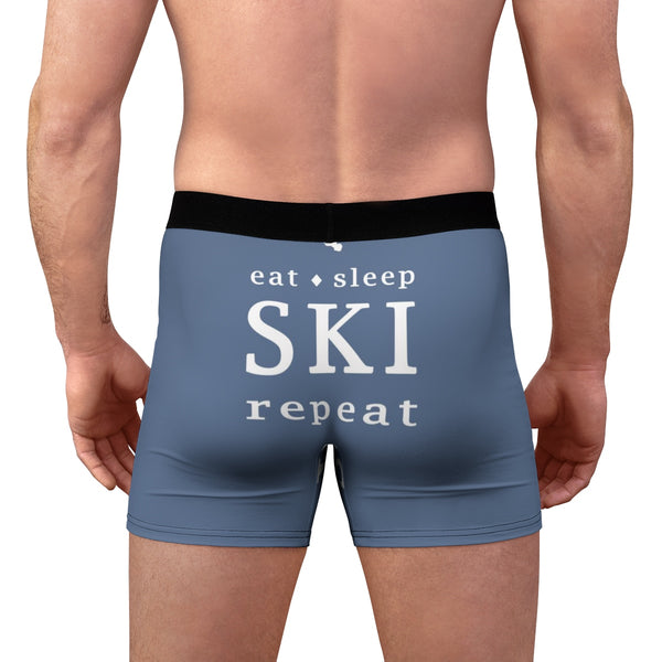 a man wearing a blue boxer shorts that says eat sleep ski repeat