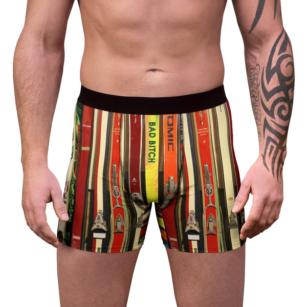 a man with a tattoo on his arm wearing a pair of colorful boxer shorts